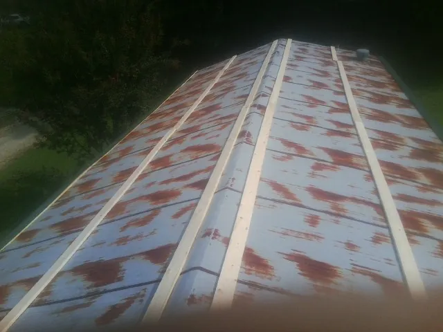 Rusted metal roof panels with new wood purlins before replacement — Storm Damage Roof Repair in Taylorsville by Roofing Brothers