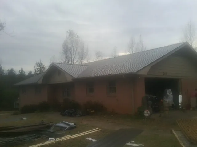 Gray metal roof on a stucco house with an attached garage in Taylorsville